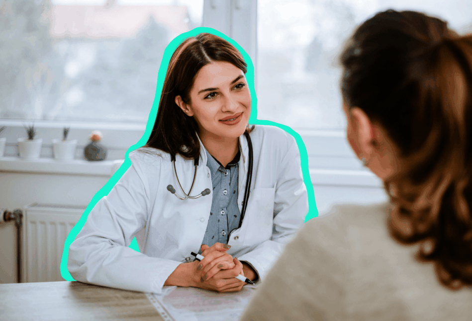 Female doctor sitting at a table talking with a patient